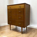 Load image into Gallery viewer, Wooden dresser with four drawers on a wooden floor against a white wall
