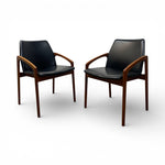 Load image into Gallery viewer, Two black leather chairs with wooden armrests on a white background
