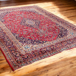 Load image into Gallery viewer, Decorative red and blue patterned rug on a wooden floor
