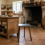Load image into Gallery viewer, Vintage kitchen with wooden island, stool, and fireplace.
