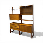 Load image into Gallery viewer, Wooden shelving unit with wicker accents on a white background
