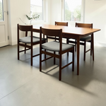 Load image into Gallery viewer, Dining table with four chairs in a room with large windows.
