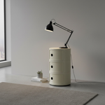 Load image into Gallery viewer, White cylindrical side table with a black lamp in a minimalistic room.
