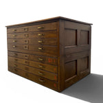 Load image into Gallery viewer, A vintage dark brown wooden storage chest with multiple drawers and brass handles, shown at an angle on a white background.
