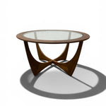 Load image into Gallery viewer, A mid-century modern round coffee table with a clear glass top and a sculptural wooden base, shown on a white background with a soft shadow.
