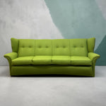 Load image into Gallery viewer, A bright lime green upholstered three-seater sofa with button tufting on the backrest and rolled arms, set against a textured gray and teal wall.

