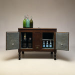 Load image into Gallery viewer, A miniature dark brown wooden cabinet with open doors, styled to look like a miniature bar cart with vintage glass soda bottles on top and inside, set against a neutral beige background.
