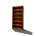 Load image into Gallery viewer, A tall wooden bookcase with five shelves, shown at a three-quarter angle against a plain white background with a soft shadow.
