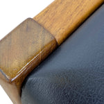 Load image into Gallery viewer, Close-up detail of a wooden armrest with a polished finish meeting a black leather upholstered section on a white background.
