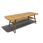 Load image into Gallery viewer, A mid-century modern wooden coffee table with a rounded rectangular top, angled legs, and a slatted lower shelf, shown on a white background with a soft shadow.
