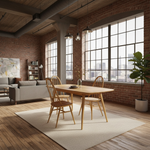 Load image into Gallery viewer, A modern dining room scene in a loft-style apartment with exposed brick walls, large industrial windows, and a light wood dining table surrounded by four wooden chairs on a cream rug. A gray sofa, bookshelves, and a potted plant are visible in the background.
