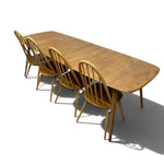 Load image into Gallery viewer, A modern wooden dining table with four matching spindle-back chairs, shown from an elevated angle on a white background with a soft shadow.
