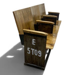 Load image into Gallery viewer, A rustic wooden stadium-style seating bench with tiered rows, dark metal supports, and white painted lettering reading 'E 5T09' on the front panel, shown on a white studio background.
