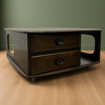 Load image into Gallery viewer, A mid-century modern wooden nightstand with two drawers and a lower shelf, shown on a light wood floor against a muted green wall.
