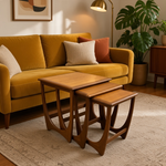 Load image into Gallery viewer, Three nested wooden nesting tables with a mid-century modern design, styled in a cozy living room next to a mustard yellow sofa.
