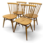 Load image into Gallery viewer, Four wooden dining chairs with spindle backs and rounded square seats, shown on a clean white background.
