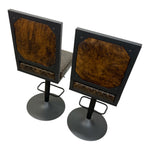 Load image into Gallery viewer, A pair of industrial-style bar stools with black metal frames, octagonal brown hair-on-hide backrests, and patterned brown seat cushions on a white background.
