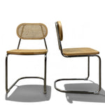 Load image into Gallery viewer, Two vintage-style cantilever chairs with woven cane seats and backs, shown from front and side angles on a white background.
