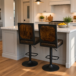 Load image into Gallery viewer, Two modern bar stools with black metal frames and brown textured faux-cow upholstery, positioned at a kitchen island with a white marble countertop in a bright, contemporary kitchen.
