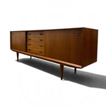 Load image into Gallery viewer, Mid-century modern wooden sideboard with a warm brown finish, featuring a central five-drawer section and a right-hand cabinet door with a pull handle, shown on a white background with a soft shadow.
