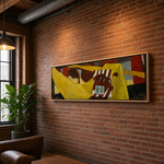 Load image into Gallery viewer, A framed abstract canvas painting with bold yellow, red, brown, and black shapes hangs on a warm brick wall in a loft-style room with a window, hanging lamp, plant, and leather chair.
